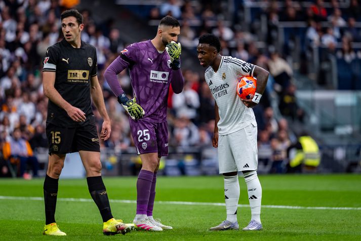 Giorgi Mamardashvili ræðir við Real Madrid stjörnuna Vinicius Junior áður en Brasilíumaðurinn tók vítið. Mamardashvili varði síðan vítið.