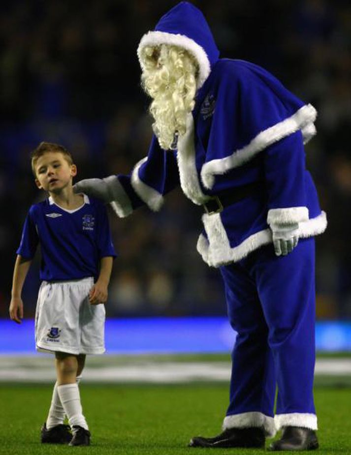 Bláklæddur jólasveinn heilsar upp á ungan stuðningsmann Everton fyrir leikinn í kvöld.