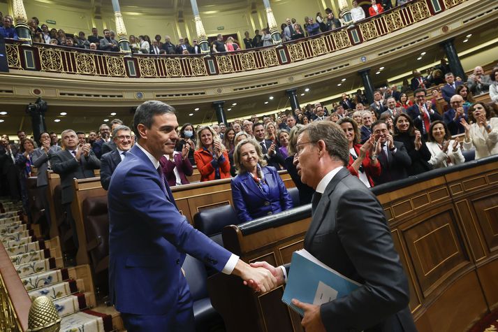 Alberto Núñez Feijóo, til hægri, tekur í spaðann á Pedro Sánchez eftir að sá síðarnefndi var kjörinn forsætisráðherra í dag.