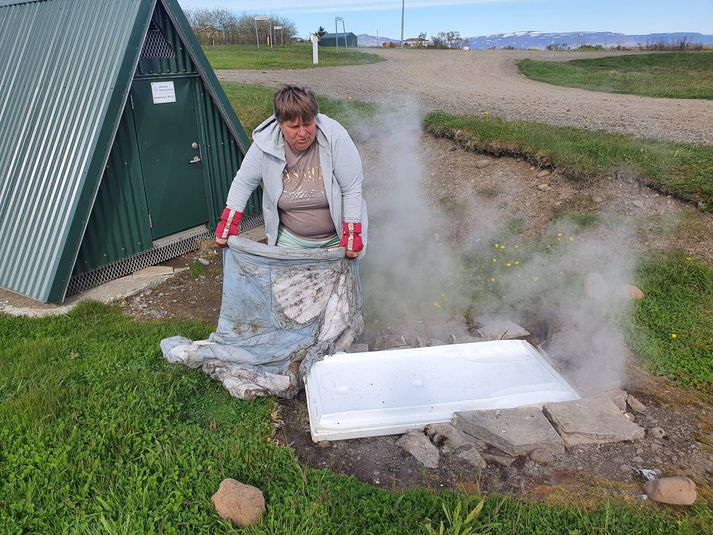 Dísa að athuga með rúgbrauðið sitt í einum af hverunum í Reykhólum en það tekur sólarhring að baka brauðið.