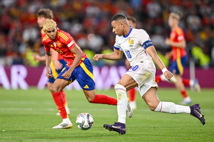 Lamine Yamal reynir að ná boltanum af Kylian Mbappé í landsleik Spánar og Frakklands.