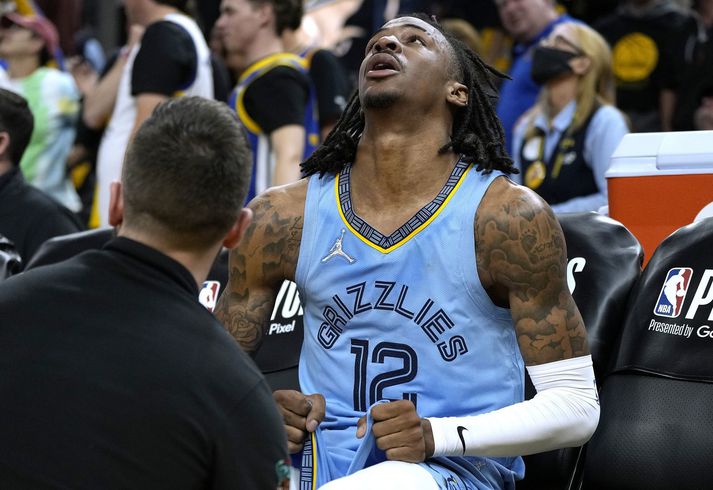  Ja Morant sést hér sárþjáður á bekknum þegar sjúkraþjálfari Memphis Grizzlies skoðar hnémeiðslin hans.