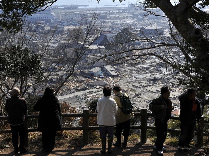 Íbúar horfa yfir rústir Ishinomaki.