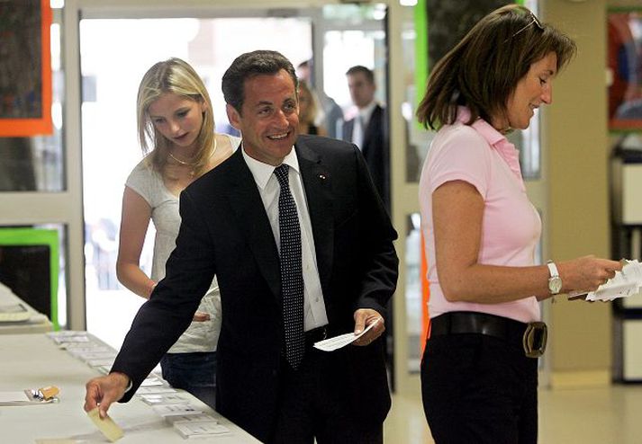 Nicolas Sarkozy forseti, eiginkona hans og fósturdóttir á kjörstað í Neuilly-sur-Saine vestur af París í gær.
