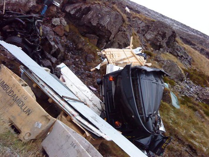 Eins og sést á þessari mynd er bíllinn mikið skemmdur og hafnaði ökumannshúsið átta metra frá klettinum.