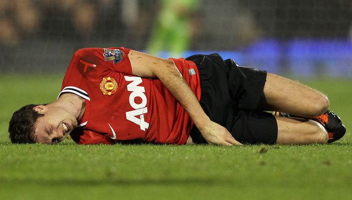 Jonny Evans liggur meiddur í grasinu.