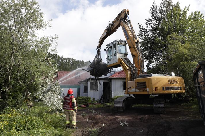 Unnið er að því að rífa húsið í Fossvogi sem brann í nótt.