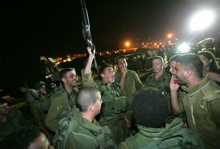 Ísraelskir hermenn fögnuðu áður en þeir héldu inn á Gaza í gær.