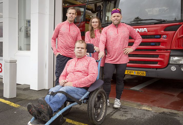 Slökkviliðsmennirnir hlaupa með sérútbúnum hlaupastólum.