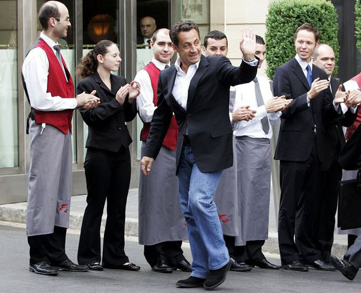 Sigursæll Sarkozy. Hinn verðandi forseti, bindislaus í gallabuxum, veifar hér vegfarendum er hann yfirgaf hótel í París í gær ásamt fjölskyldu sinni. Hann hyggst verja næstu dögum í friði fyrir kastljósi fjölmiðlanna.