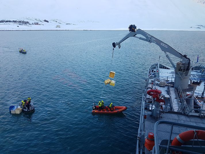 Varðskipið Þór við hreinsun í höfninni á Flateyri í dag.