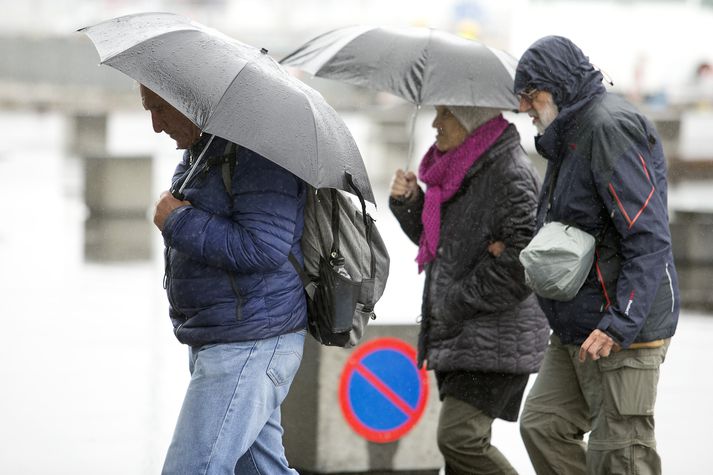 Ferðamenn í rigningu og dumbungi í Reykjavík.