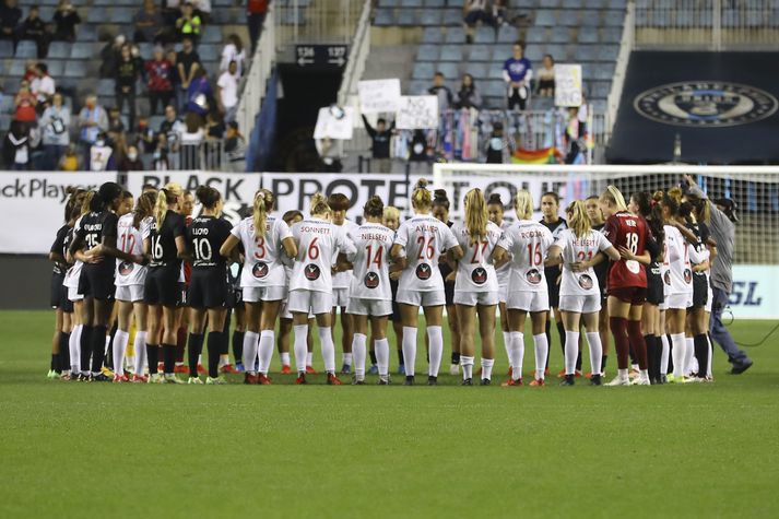 Leikmenn Washington Spirit og Gotham FC safnast saman á miðjum vellinum. Það sama gerðu leikmenn í leikjum North Carolina Courage og Racing Louisville og Houston Dash og Portland Thorns.