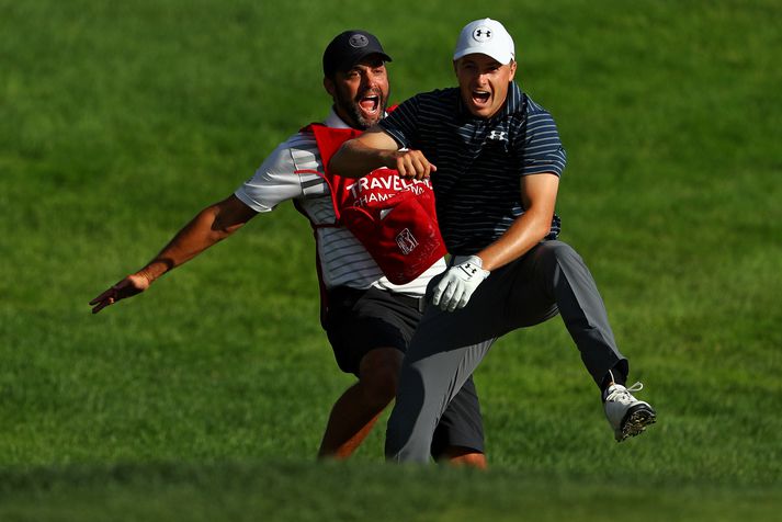 Jordan Spieth fagnar með kylfusveini sínum.