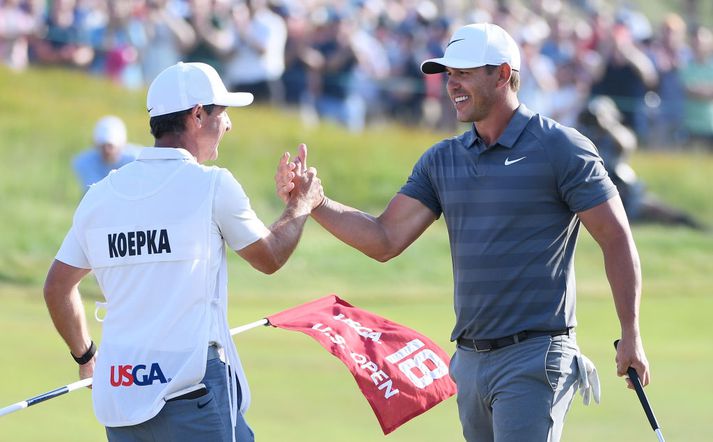 Koepka og kylfusveinn hans fagna í kvöld