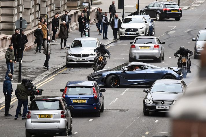 Tvö mótorhjól elta McLaren-sportbíl yfir George-torgið í Glasgow. Um 200 manns koma að verkefninu.