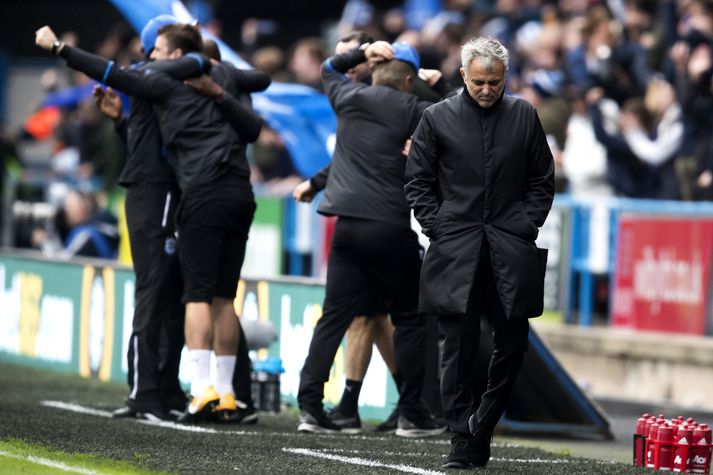 Mourinho gengur niðurlútur af velli í dag á meðan þjálfarateymi Huddersfield fagnar.