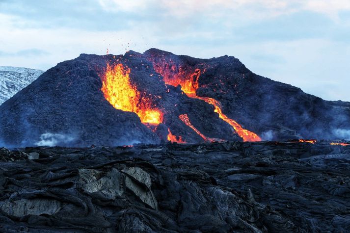 Mynd sem ljósmyndari Vísis tók við gosstöðvarnar í kvöld. Lengst til hægri má sjá hvernig hraunið glóir enn þrátt fyrir að vera langt frá gígunum tveimur.