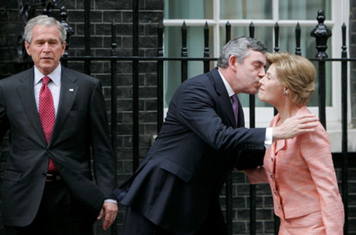 Gordon Brown smellir kossi á kinn Lauru Bush á meðan George horfir á.