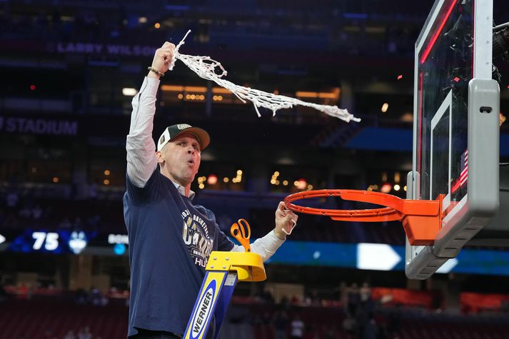 Dan Hurley klippir netið af körfunni eftir að Connecticut vann Purdue í úrslitaleik háskólaboltans.