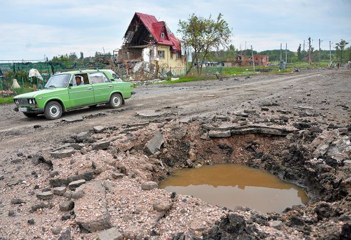 Mikil eyðilegging Ekið framhjá sprengjugíg nálægt borginni Slavyansk sem stjórnarherinn náði tökum á um síðustu helgi.