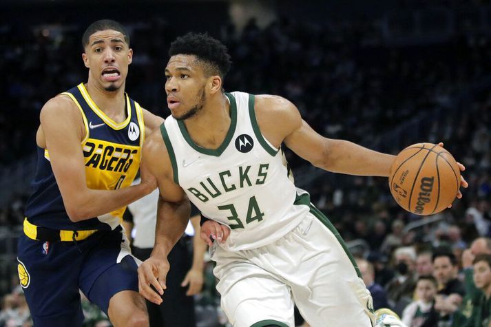 Giannis Antetokounmpo keyrir að körfu Indiana Pacers en Tyrese Haliburton reynir að verjast.