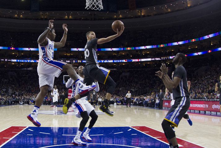 Curry laumar hér boltanum ofaní körfuna framhjá varnarmönnum 76ers.