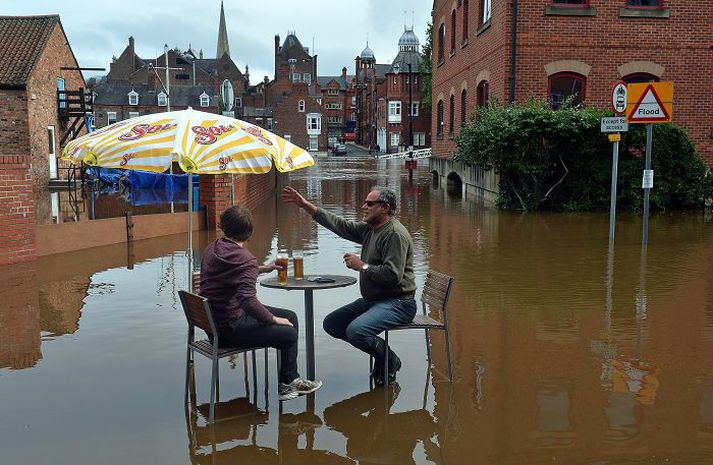 Meðan flóðið hækkar Þeir settust bara niður og fengu sér bjór fyrir utan knæpu í York.nordicphotos/AFP