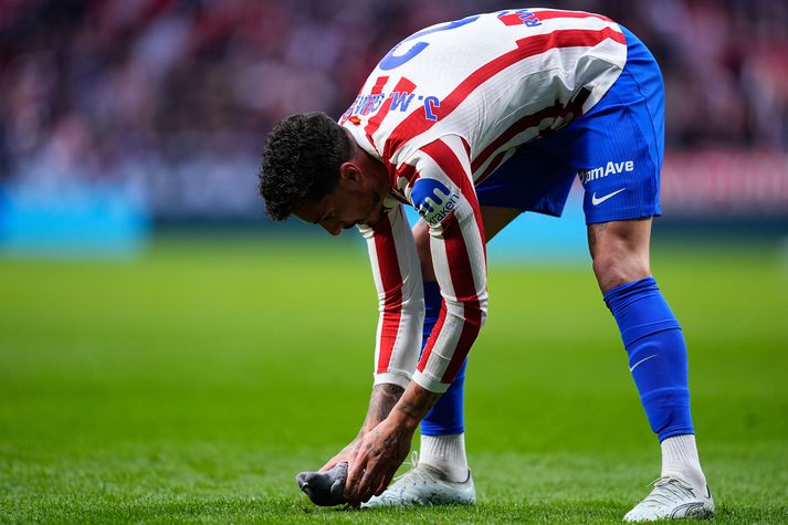 Jose Maria Gimenez hjá Atletico de Madrid sést hér taka upp dúfuna af grasinu.