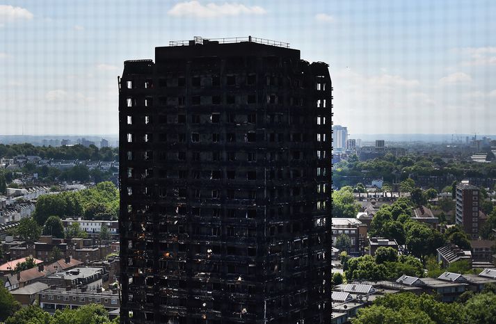 Sviðinn Grenfell-turninnn í London eftir eldsvoðann sem braust út á aðfaranótt miðvikudags.