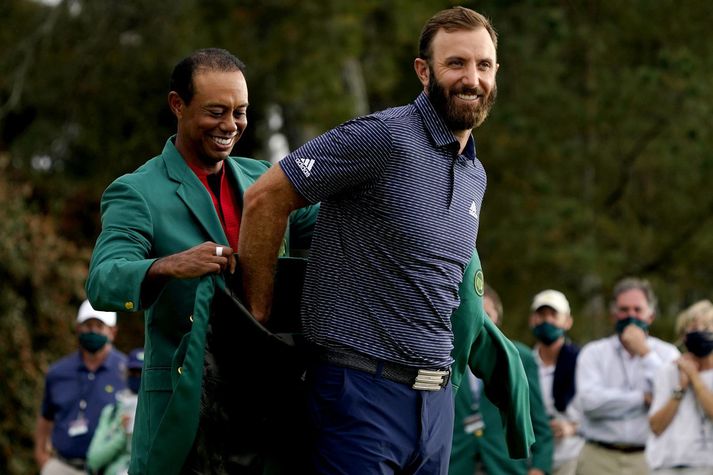 Tiger Woods klæðir Dustin Johnson hér í græna jakann fræga eftir sigurinn á Mastersmótinu í gær.