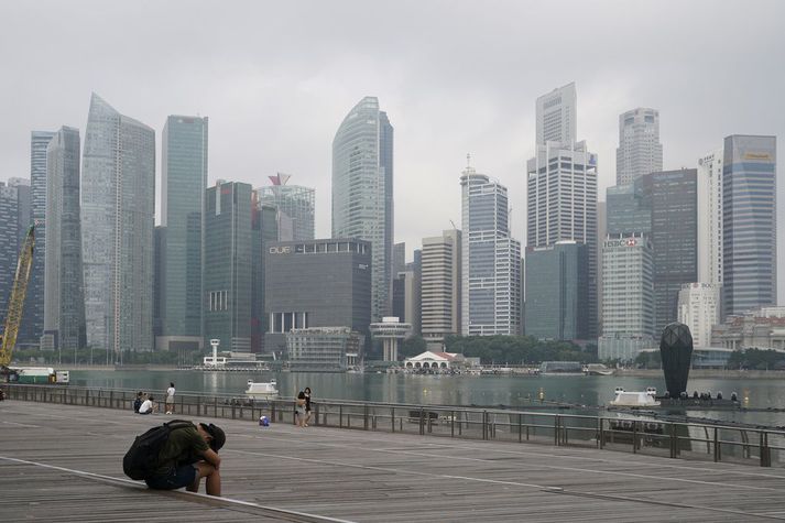 Maður leggur sig við sjávarsíðuna við fjármálahverfið í Singapúr. Singapúr tekur hart á glæpum sem tengjast sölu á vímuefnum.