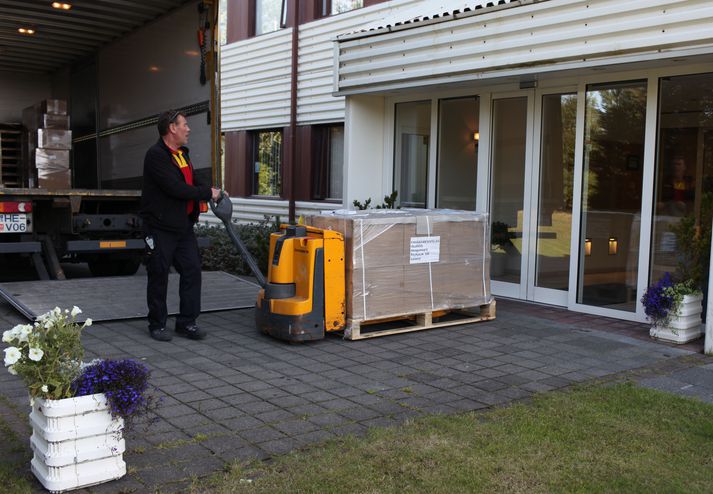 Á myndinni sést Kristinn Ingibergsson, starfsmaður DHL, renna Bleiku slaufunni í hús.