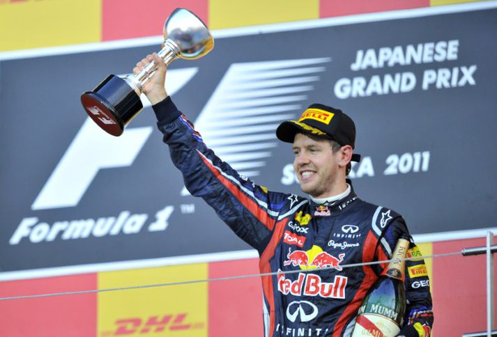 Heimsmeistarinn ungi Sebastian Vettel hefur hér á loft bikarinn fyrir þriðja sætið í kappakstrinum í morgun.