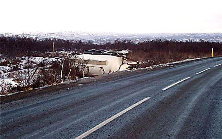 Hættulegur vegur. Séð úr fjarlægð virðist vegurinn auður en þegar nær er komið sést ísingin. Ökumaður steypubílsins áttaði sig ekki á lúmskri hálkunni.