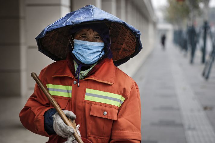 Íbúi Wuhan-borgar, klæddur andlitsgrímu. Viðbúnaður vegna veirunnar er mikill.