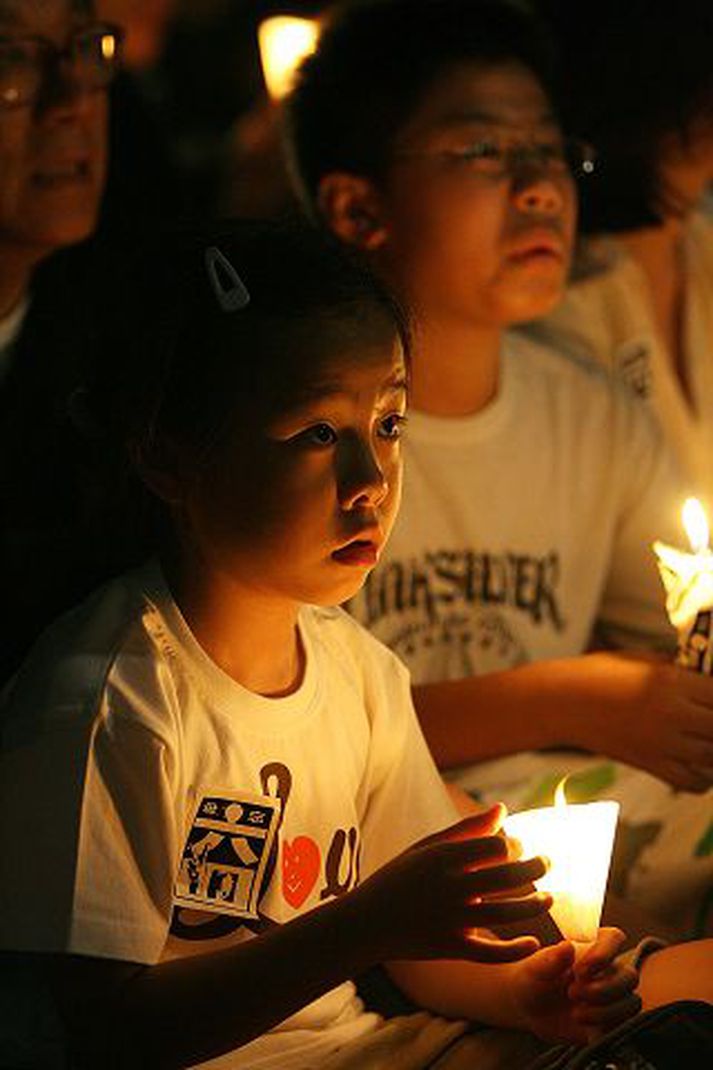 Börn í Hong Kong tendra friðarljós í minningu harmleiksins.