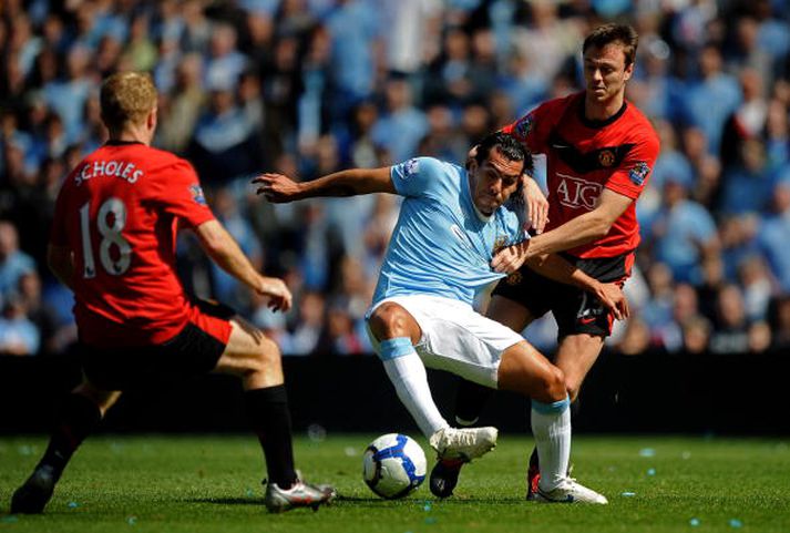 Carlos Tevez í baráttu við Johnny Evans og Paul Scholes í slagnum í dag.