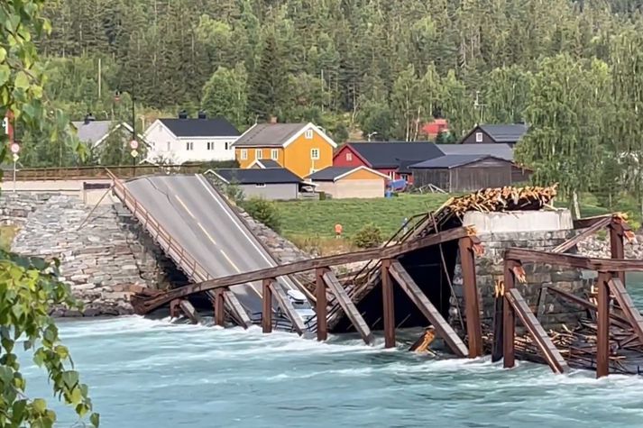 Brúin hrundi í morgun og höfnuðu tveir bílar að hluta til í ánni.