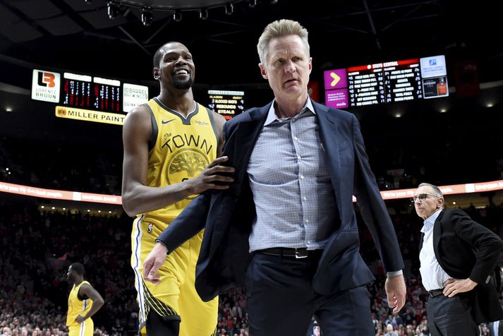 Brosandi Kevin Durant hjálpar þjálfara sínum Steve Kerr af velli eftir að Kerr hafði verið rekinn út úr húsi.