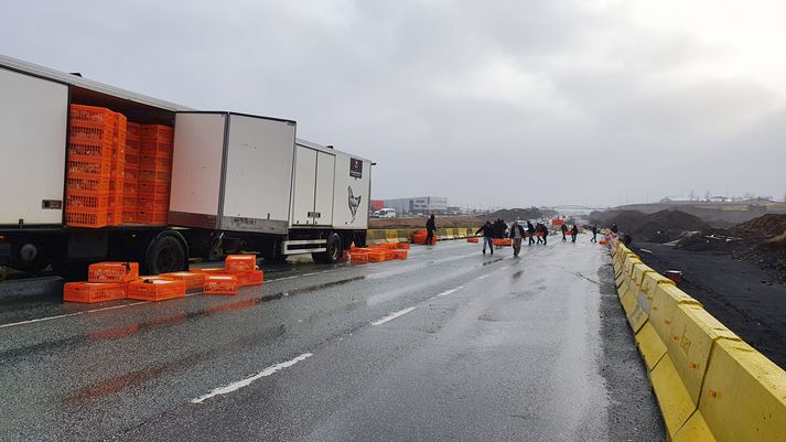 Vegfarendur aðstoðuðu við að koma farminum aftur um borð í bílinn.