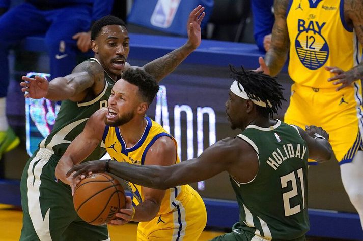 Stephen Curry skýtur sér á milli Khris Middleton og Jrue Holiday í San Francisco í nótt.