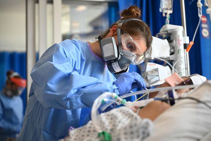 Heilbrigðisstarfsmaður í hlífðarklæðnaði hugar að sjúklingi á sjúkrahúsi í Cambridge á Englandi. Víða um heim hefur heilbrigðisstarfsfólk skort nauðsynlegan hlífðarbúnað.