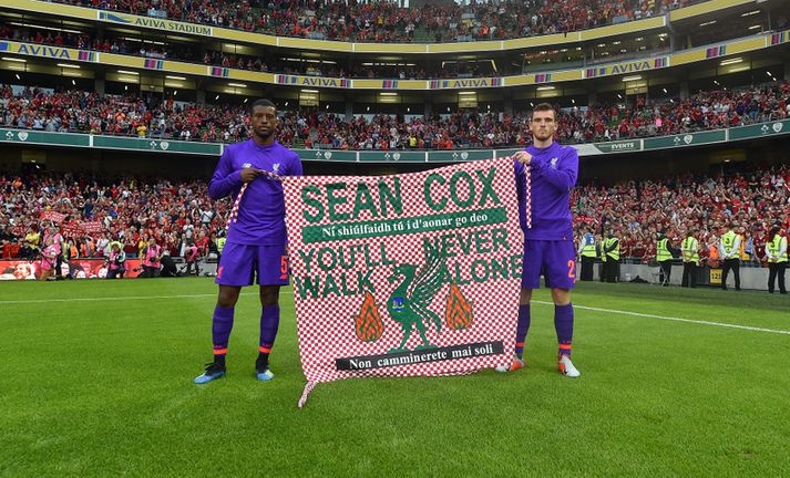 Liverpool leikmennirnir Andy Robertson og Georginio Wijnaldum með fána til stuðnings Sean Cox.