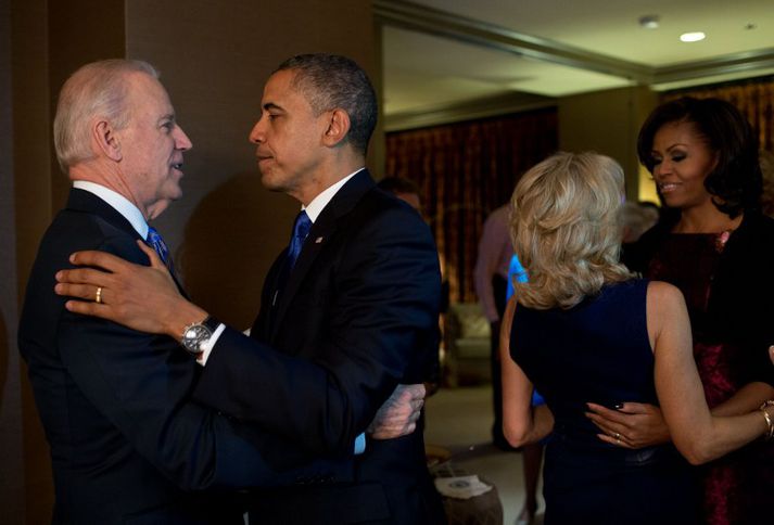 Barack Obama, forseti Bandaríkjanna, og Joe Biden varaforseti óska hvor öðrum til hamingju. Í baksýn eru eiginkonur þeirra.