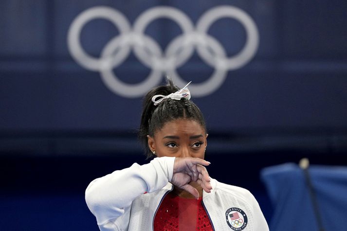 Simone Biles fylgist með liðsfélögum sínum keppa í gær en hún breytti sér í klappstýru í liðakeppninni eftir að hafa hætt í miðri keppni.