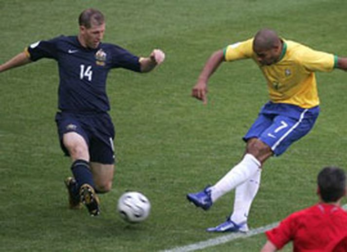 Adriano spyrnir knettinum inn í mark Ástrala, Scott Chipperfield nær ekki að stöðva skotið.