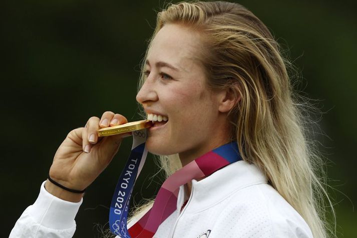 Nelly Korda bítur í Ólympíugullið sitt eftir sigur sinn á leikunum í Tókýó í sumar.