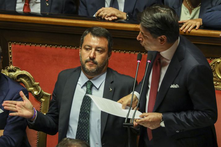 Conte í ræðustól en Salvini lætur sér fátt um finnast.