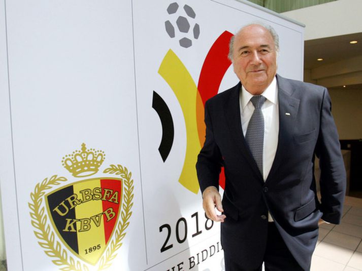 Sepp Blatter, forseti FIFA, fyrir framan merki framboðs Hollendinga og Belga.
